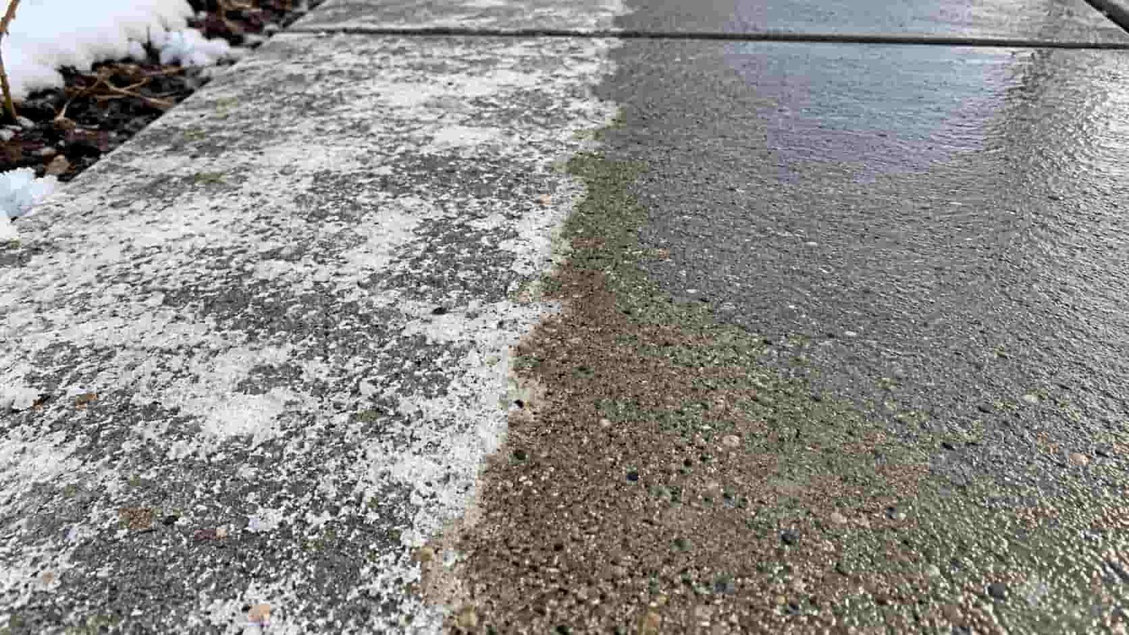Concrete walkway with white winter salt residue on the left and freshly washed concrete on the right.